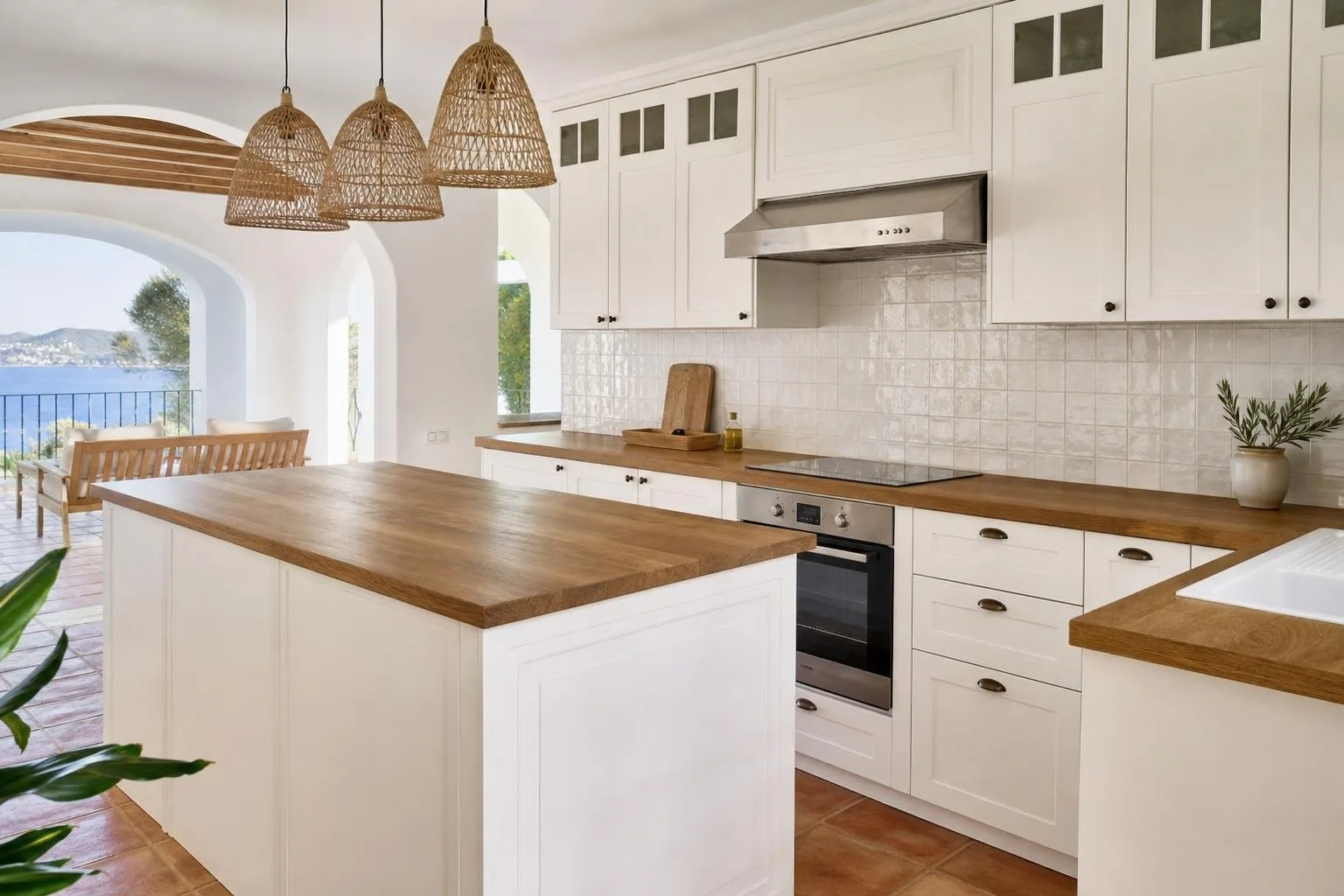 Cocina abierta reformada con muebles blancos y encimera de madera