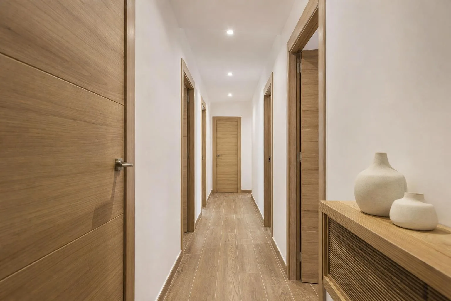 Pasillo de apartamento reformado con puertas y suelo nuevos