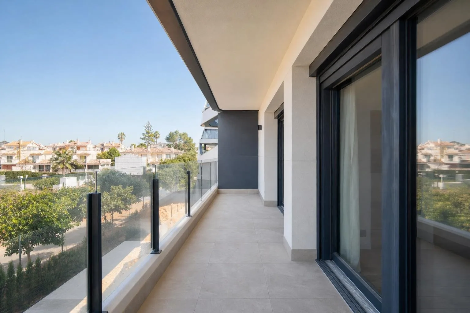 Balcón de apartamento reformado con suelo nuevo y barandilla de cristal